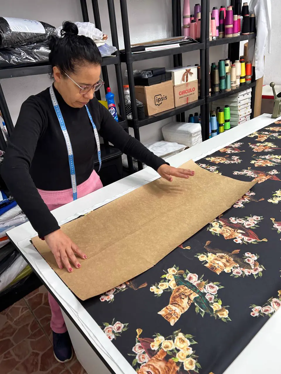 Costureira ajustando o molde de papel sobre o tecido